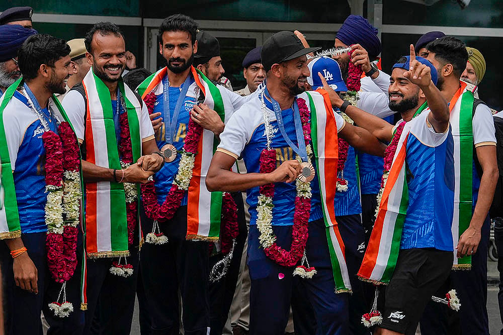 | Photo: PTI/Manvender Vashist Lav : Bronze medalist Indian Hockey players at the Indira Gandhi International Airport